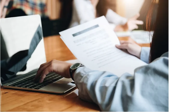 Reunión de trabajo con un portátil y un documento sobre la mesa